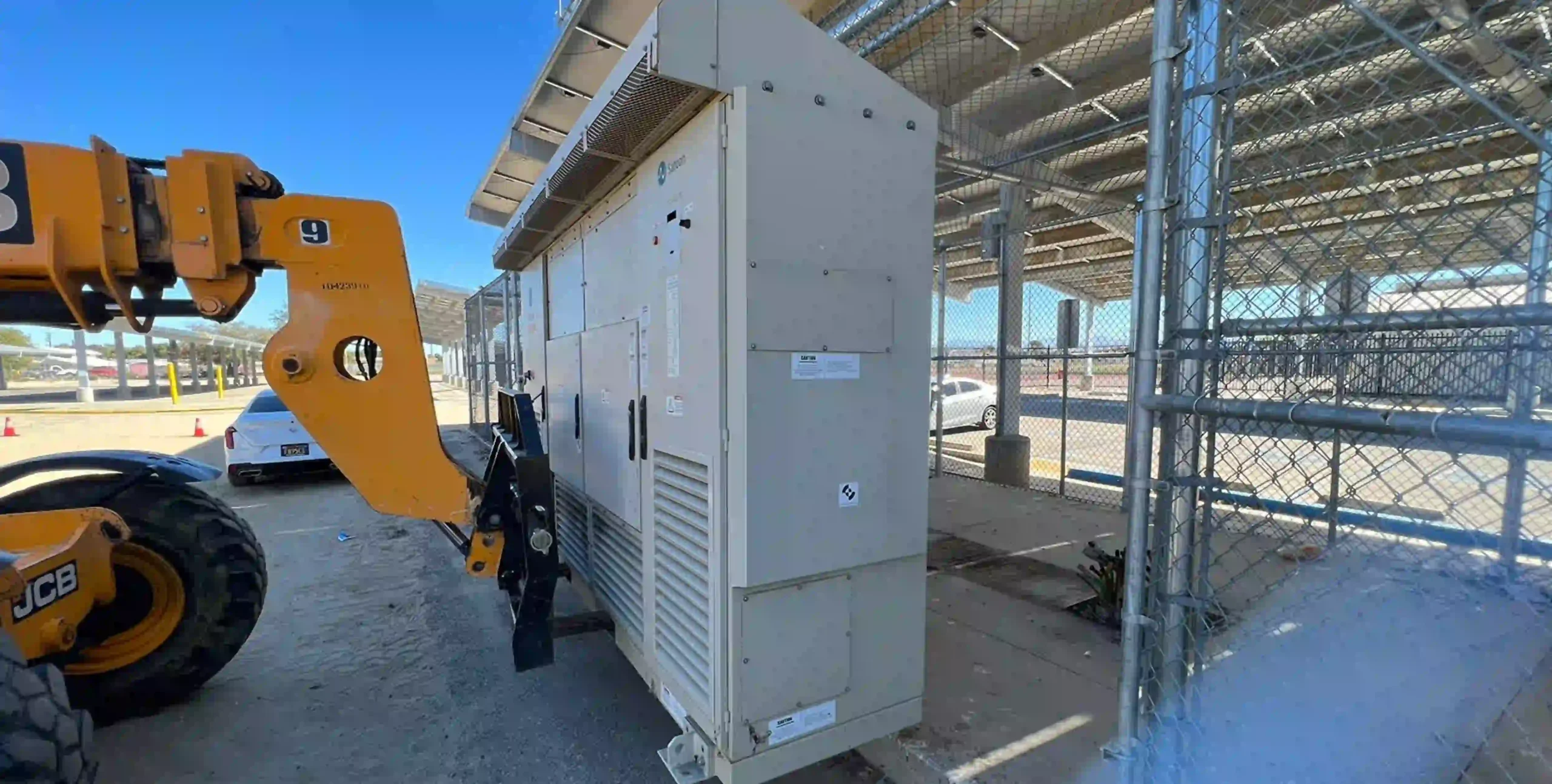Battery energy storage cabinet installed at solar site with construction equipment nearby