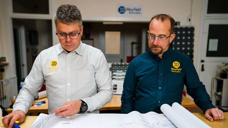 Mayfield Renewables engineers review technical Mayfield Renewables engineers review technical drawings during clean energy project planning drawings during clean energy project planning