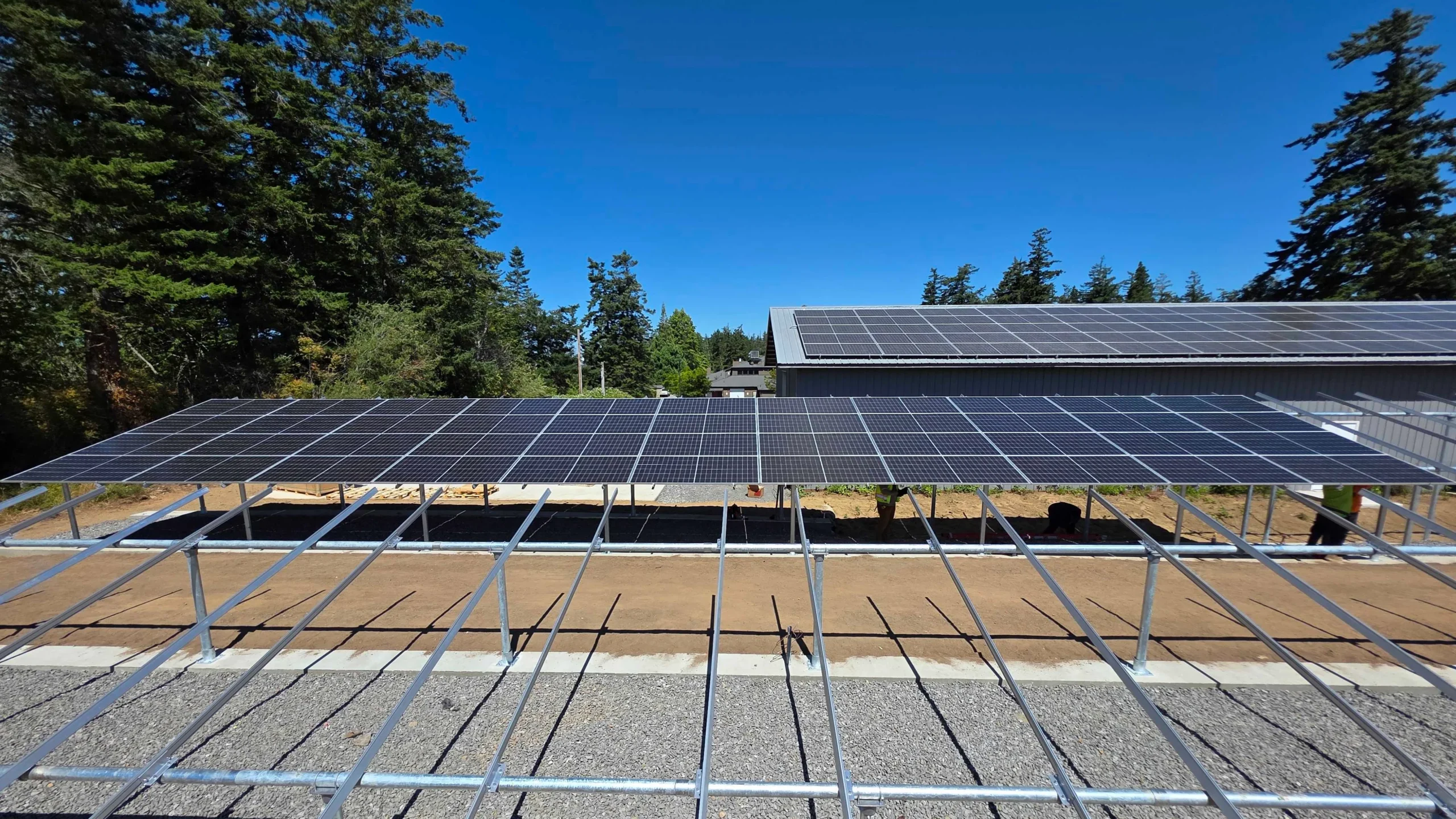 Ground-mounted solar panel array installation with metal racking on sunny day